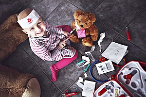 Kind mit Teddy Kind spielt mit Teddy "Doktor"